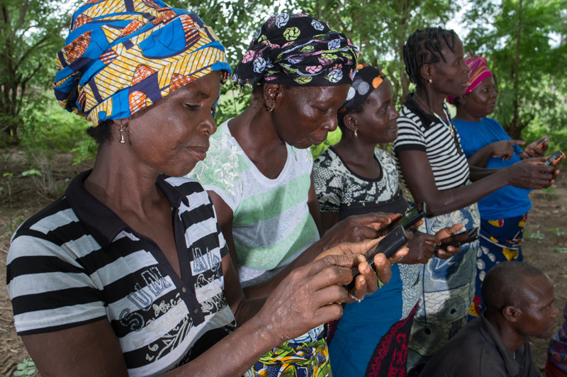 Women use their mobile phones to receive weather data via text messages. Photo: Klaus Wohlmann, GIZ
