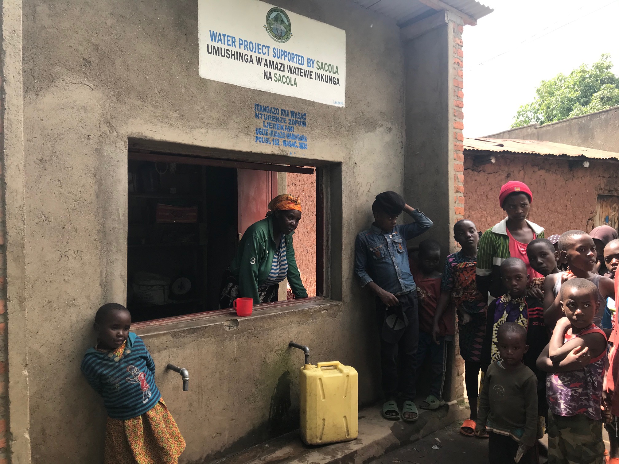 Planetary health solutions: in Rwanda, a woman welcomes local people and collects payments for water, money that is reinvested in the community. © Nicole de Paula
